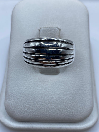 Anillo de plata con bandas paralelas pulidas en la mano de una mujer