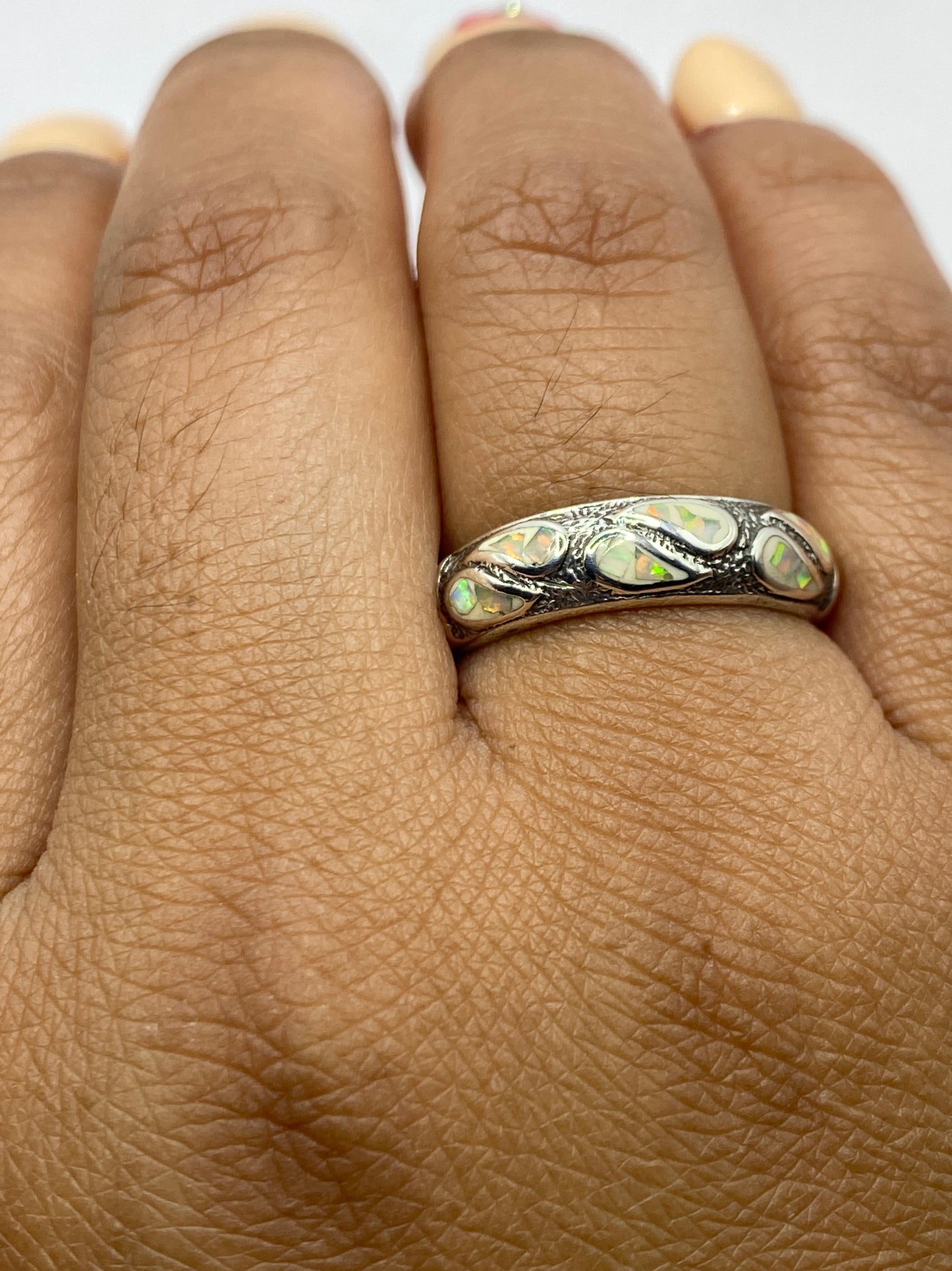 Anillo de ópalo de fuego puesto en la mano mostrando los destellos de luz