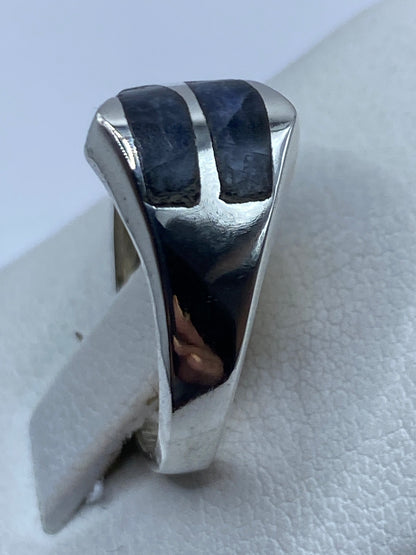 Anillo en la mano mostrando el acabado pulido y la piedra azul