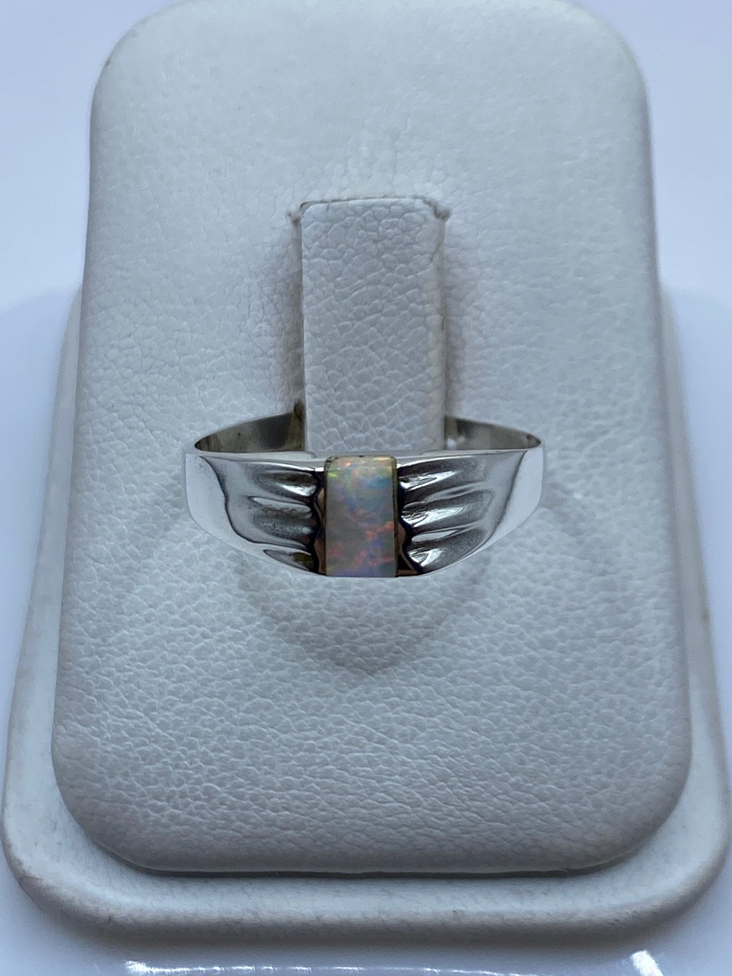 Anillo de plata .950 con ópalo de fuego multicolor iridiscente en mano de mujer