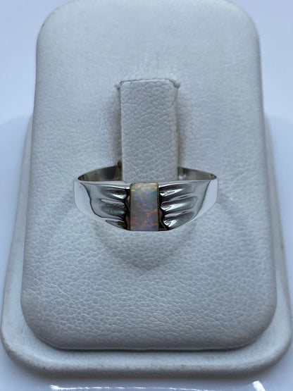 Anillo de plata .950 con ópalo de fuego multicolor iridiscente en mano de mujer