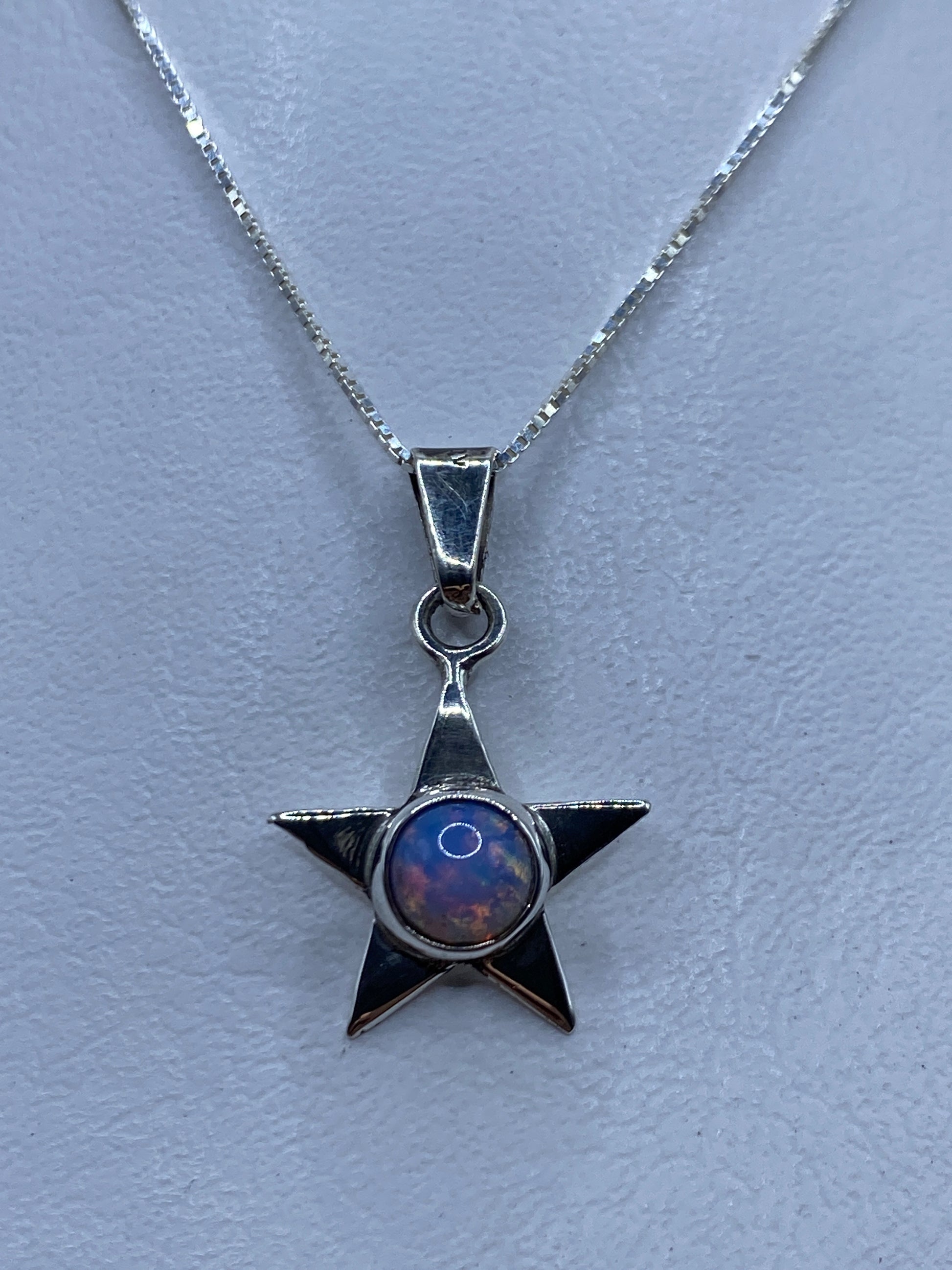 Dije estrella de plata .925 con piedra multicolor engastada, sobre cadena fina
