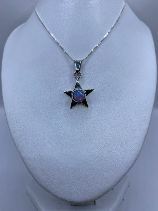 Detalle frontal del dije estrella mostrando el engaste de la piedra multicolor