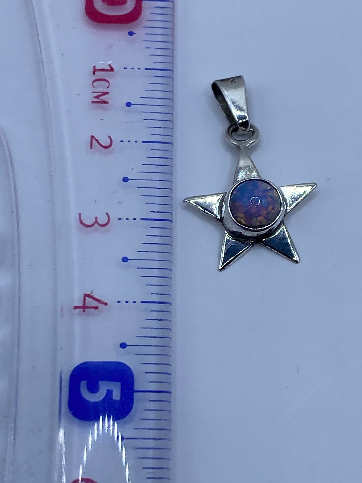 Dije estrella en plata pulida sobre fondo blanco