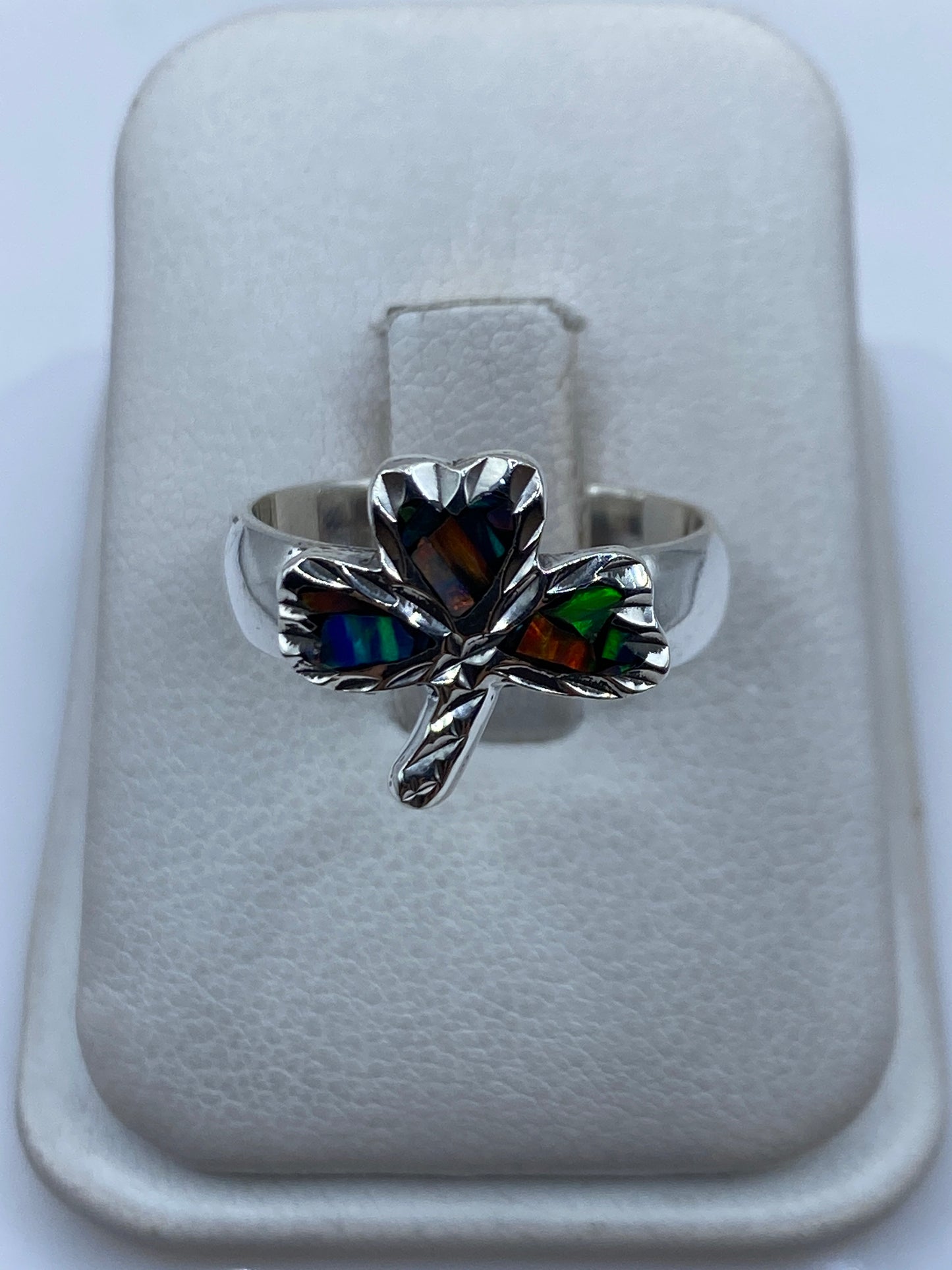 Anillo de plata con ópalo de fuego multicolor en forma de tres pétalos sobre fondo blanco
