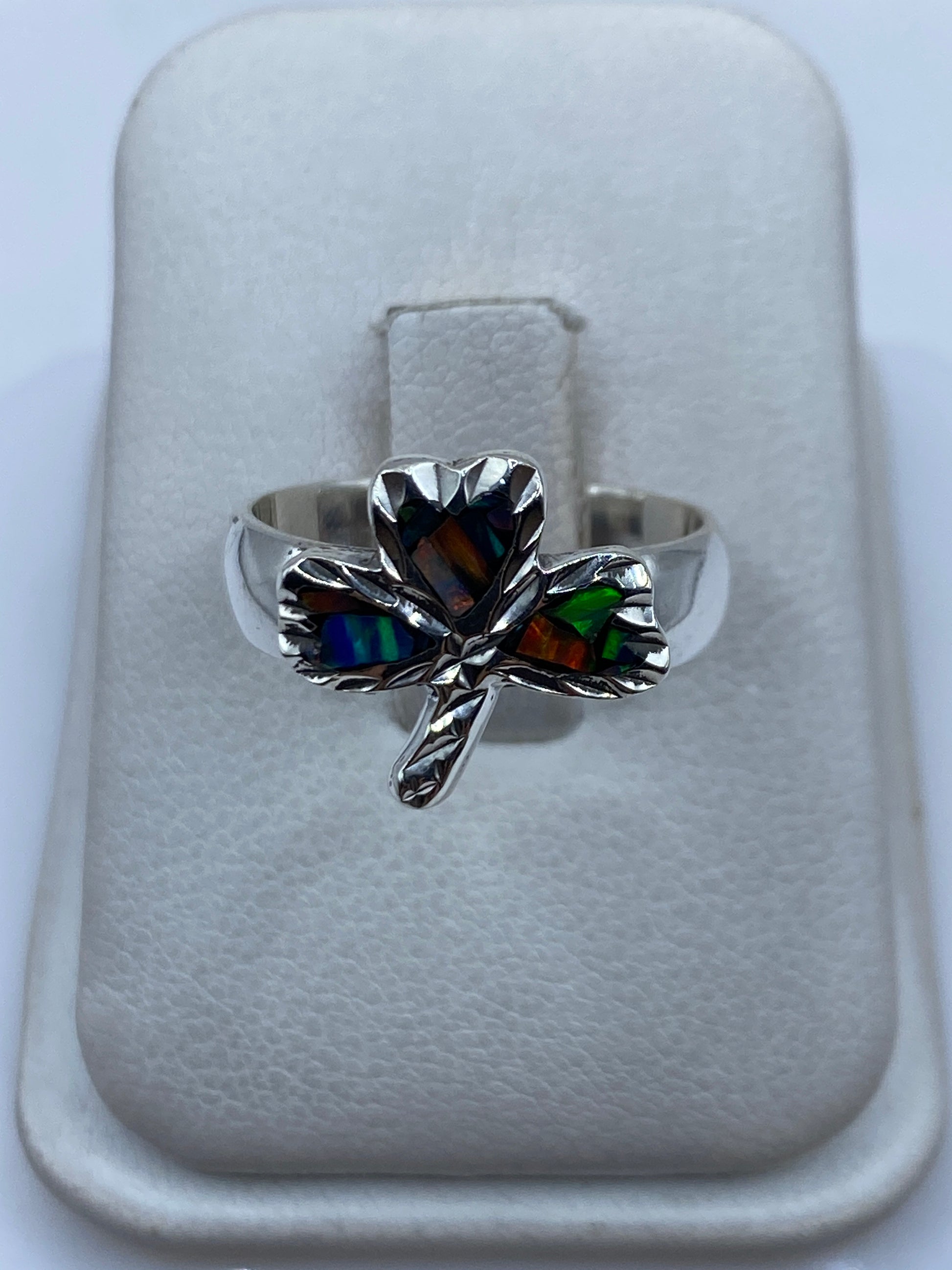 Anillo de plata con ópalo de fuego multicolor en forma de tres pétalos sobre fondo blanco