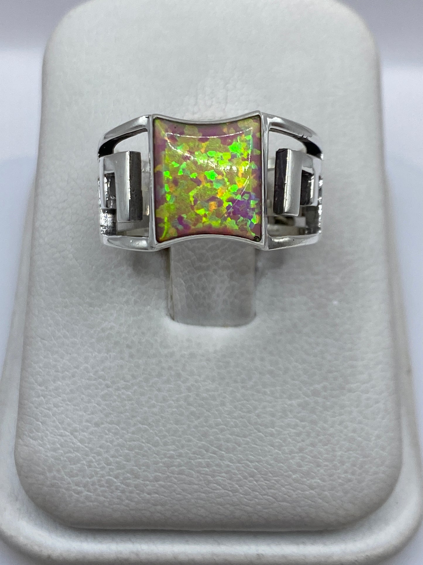 Anillo de plata con ópalo de fuego rosa en tono frontal mostrando el brillo multicolor