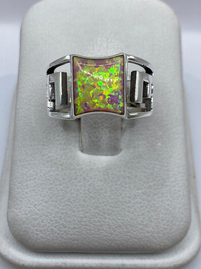 Anillo de plata con ópalo de fuego rosa en tono frontal mostrando el brillo multicolor