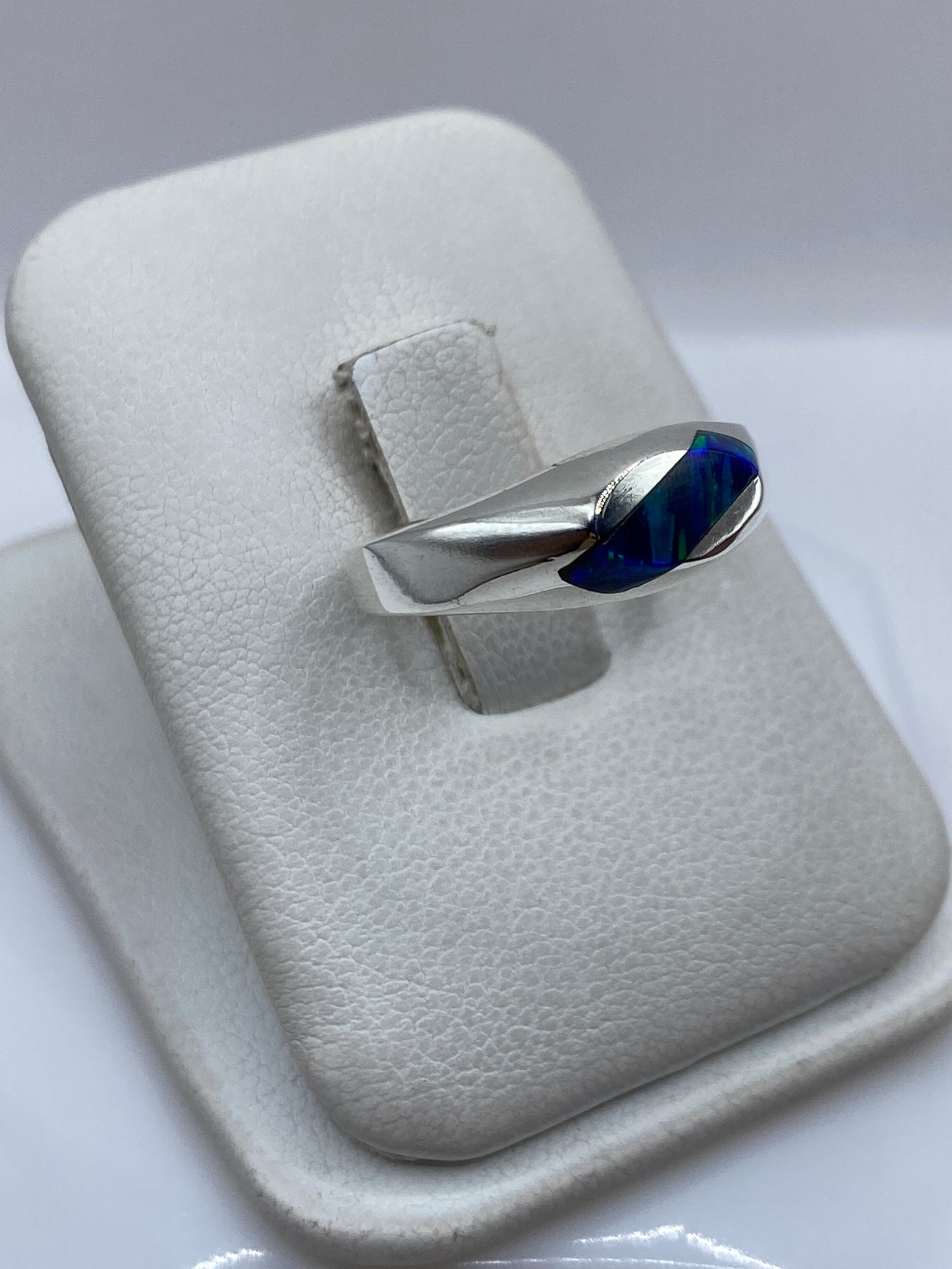 Vista frontal del anillo de ópalo azul con engaste en plata pulida de Taxco