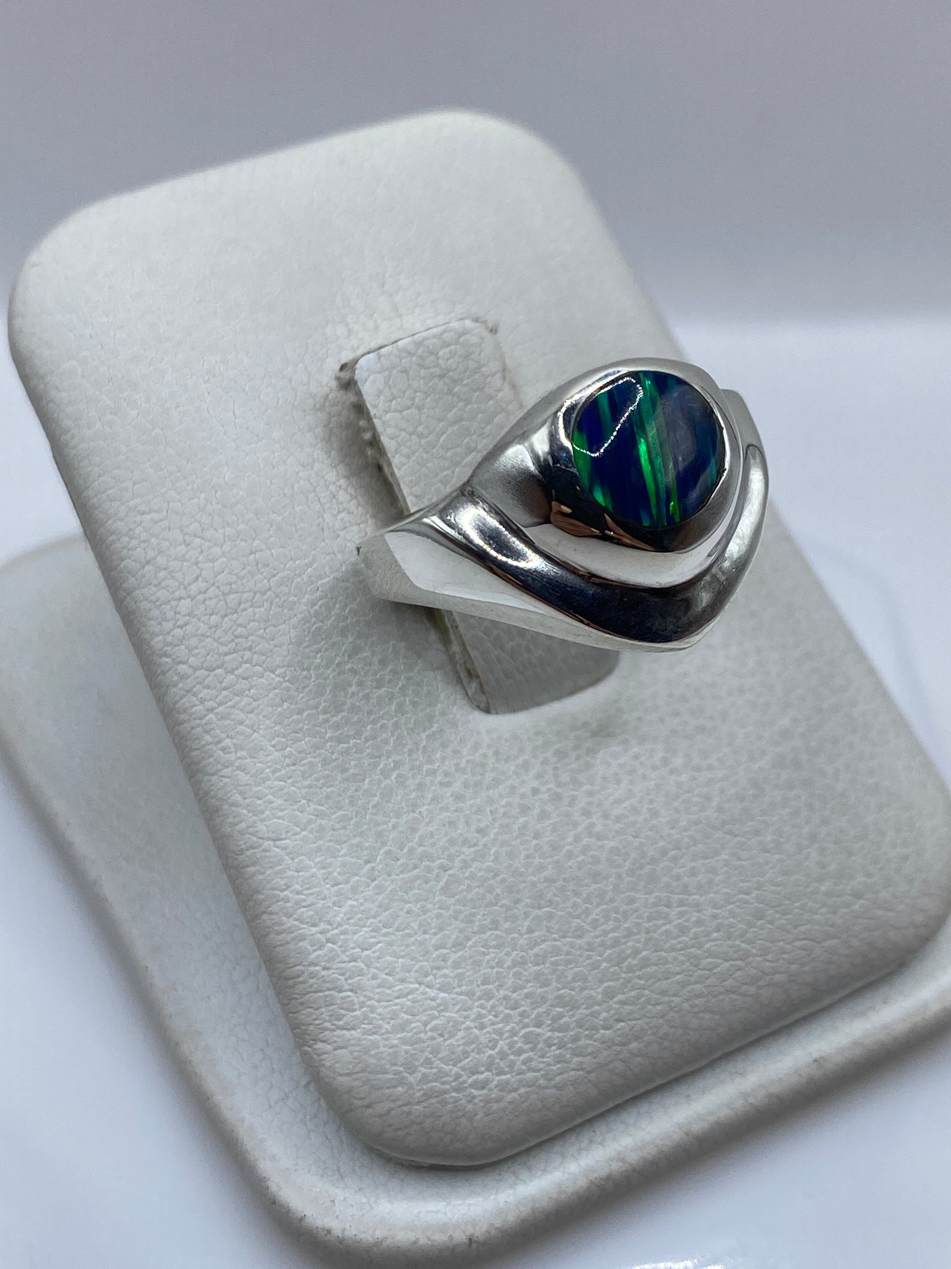 Detalle frontal del ópalo de fuego azul engastado en plata, mostrando el juego de luz