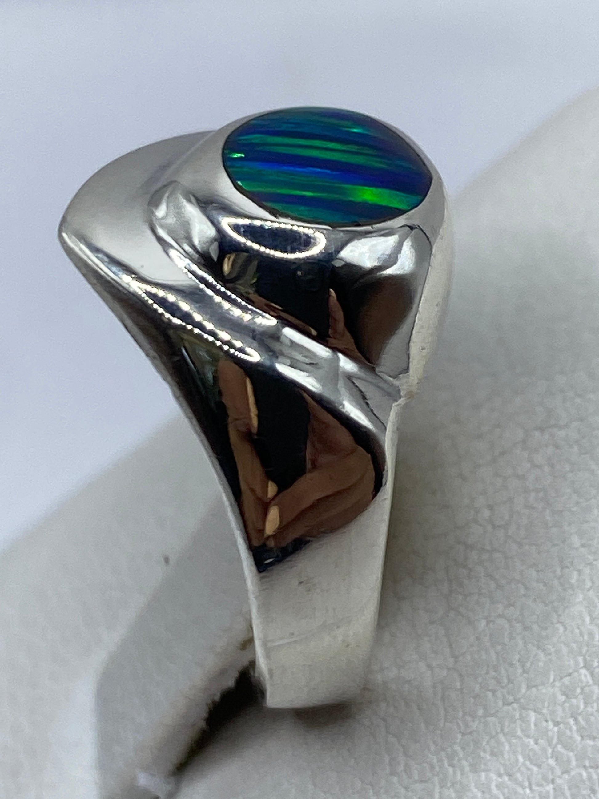 Anillo en la mano mostrando el tono azul verdoso del ópalo de fuego