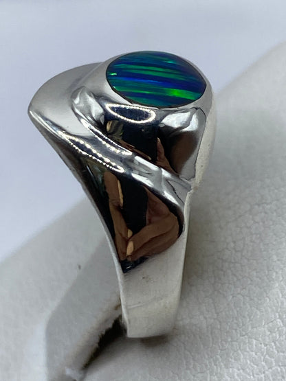 Anillo en la mano mostrando el tono azul verdoso del ópalo de fuego