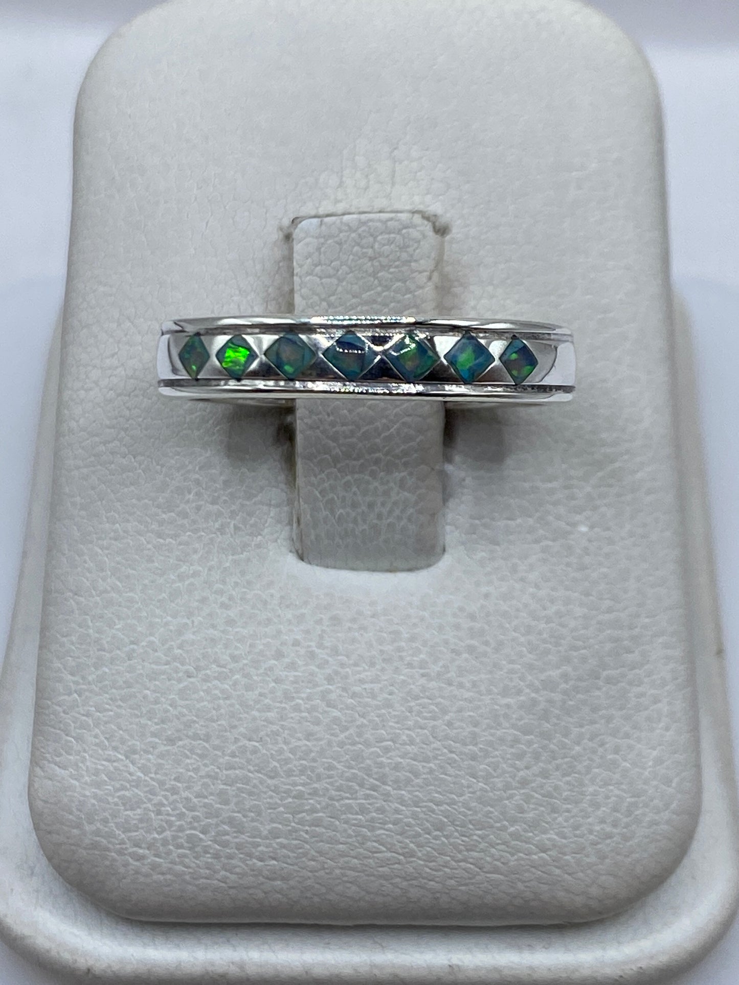 Anillo de plata .950 con Ópalo de Fuego azul cielo engastado a mano, vista frontal sobre anular