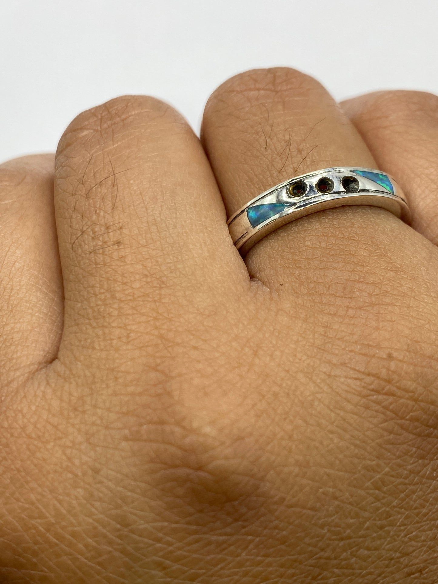 Anillo en la mano mostrando cómo la luz atraviesa el ópalo de fuego
