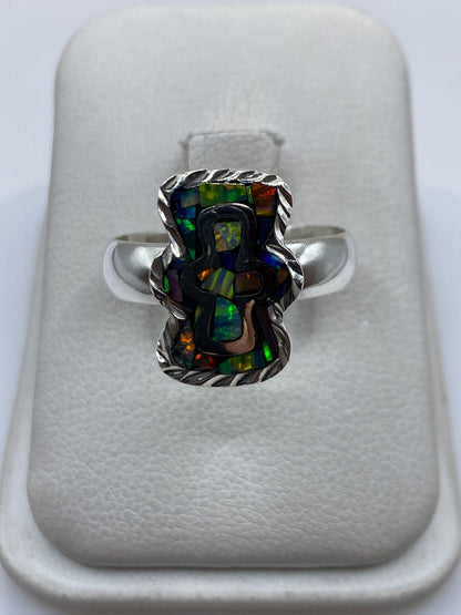 Anillo de plata .950 con ópalo de fuego multicolor en color verdes, azules y naranjas, sobre fondo blanco