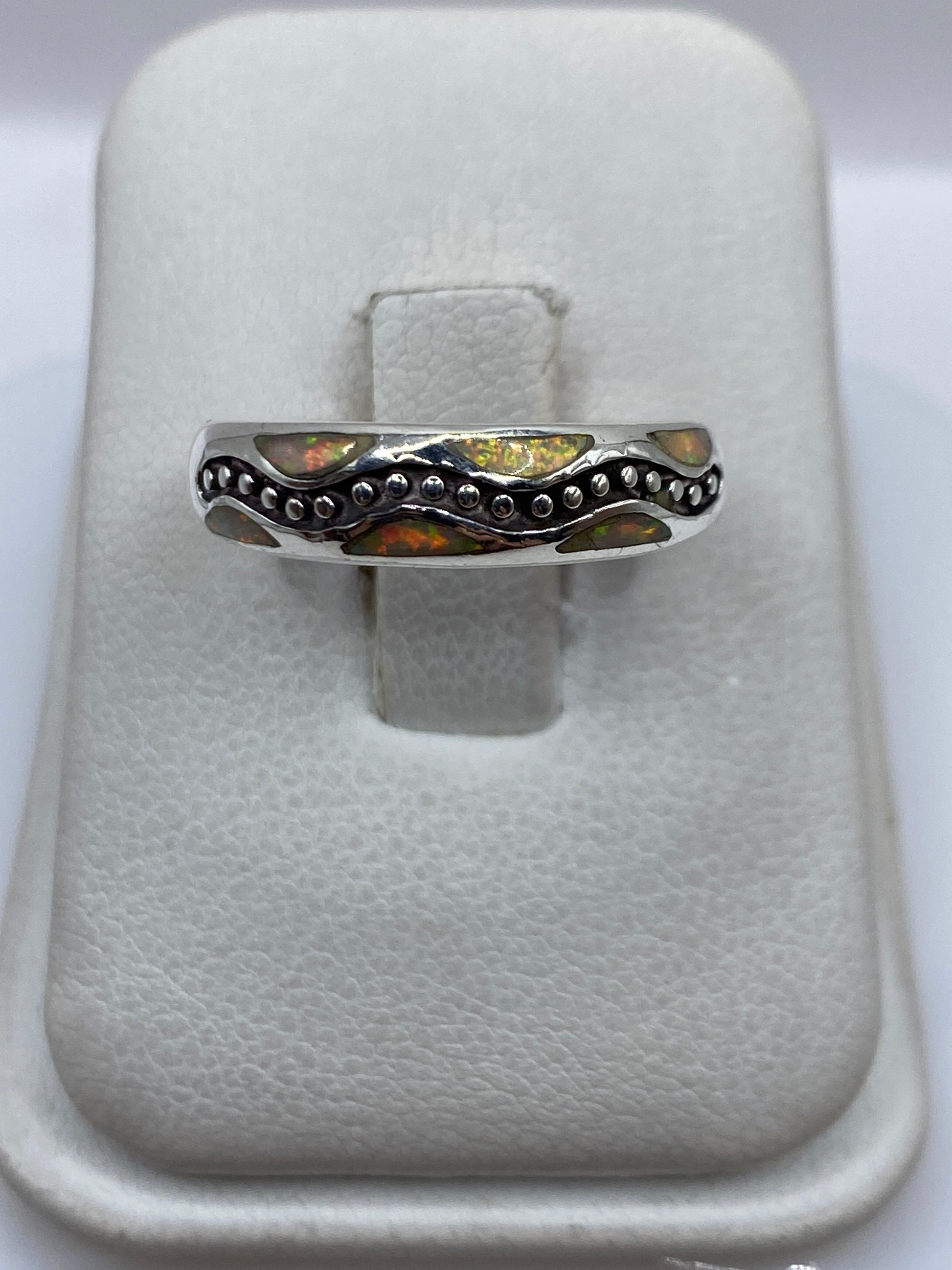Anillo de plata .950 con ópalo de fuego amarillo en vaina de granulados, visto desde arriba en estuche blanco