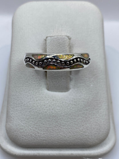 Anillo de plata .950 con ópalo de fuego amarillo en vaina de granulados, visto desde arriba en estuche blanco