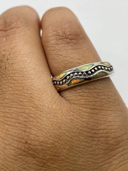 Anillo de plata .950 puesto en dedo mostrando el color amarillo del ópalo de fuego con la marca .950 visible