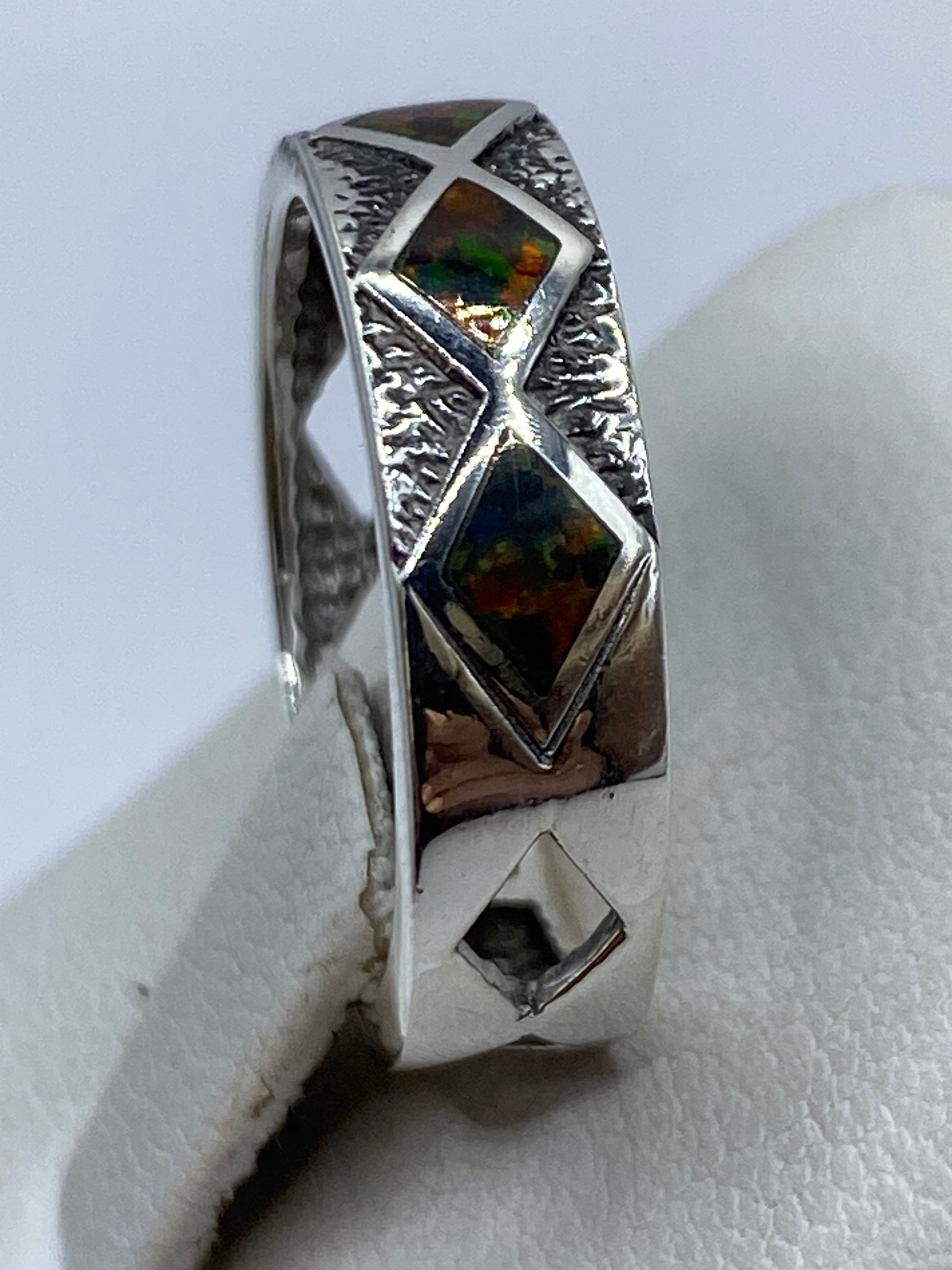 Anillo puesto en dedo índice, ópalo brillando con luz natural