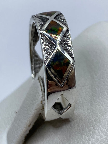 Anillo puesto en dedo índice, ópalo brillando con luz natural