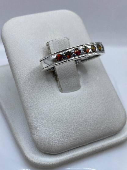 Detalle del engaste a mano del ópalo de fuego en plata .950, colores naranja, rojo y verde