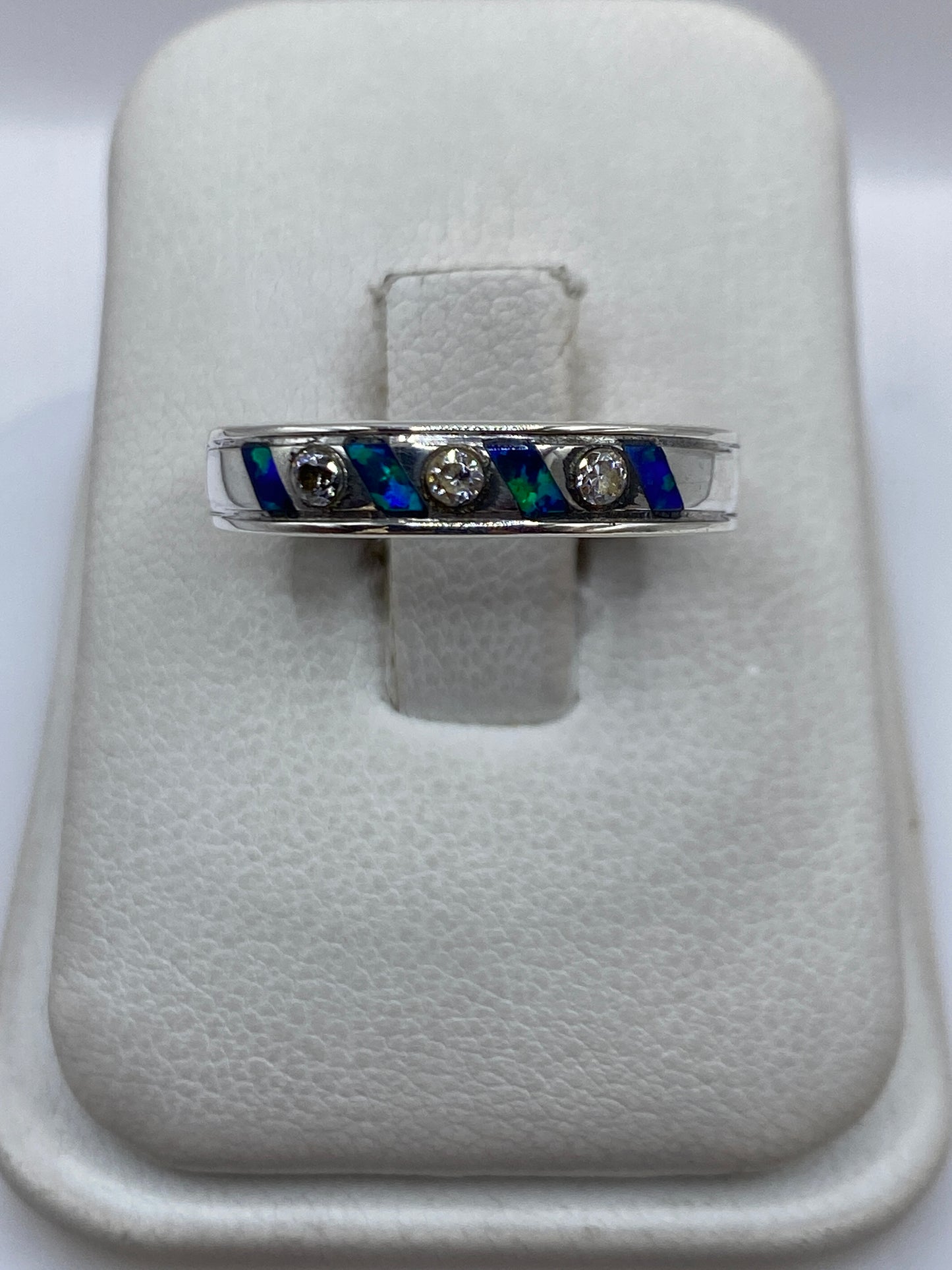 Anillo de plata .950 con ópalo de fuego azul incrustado en banda ancha, sobre blanco