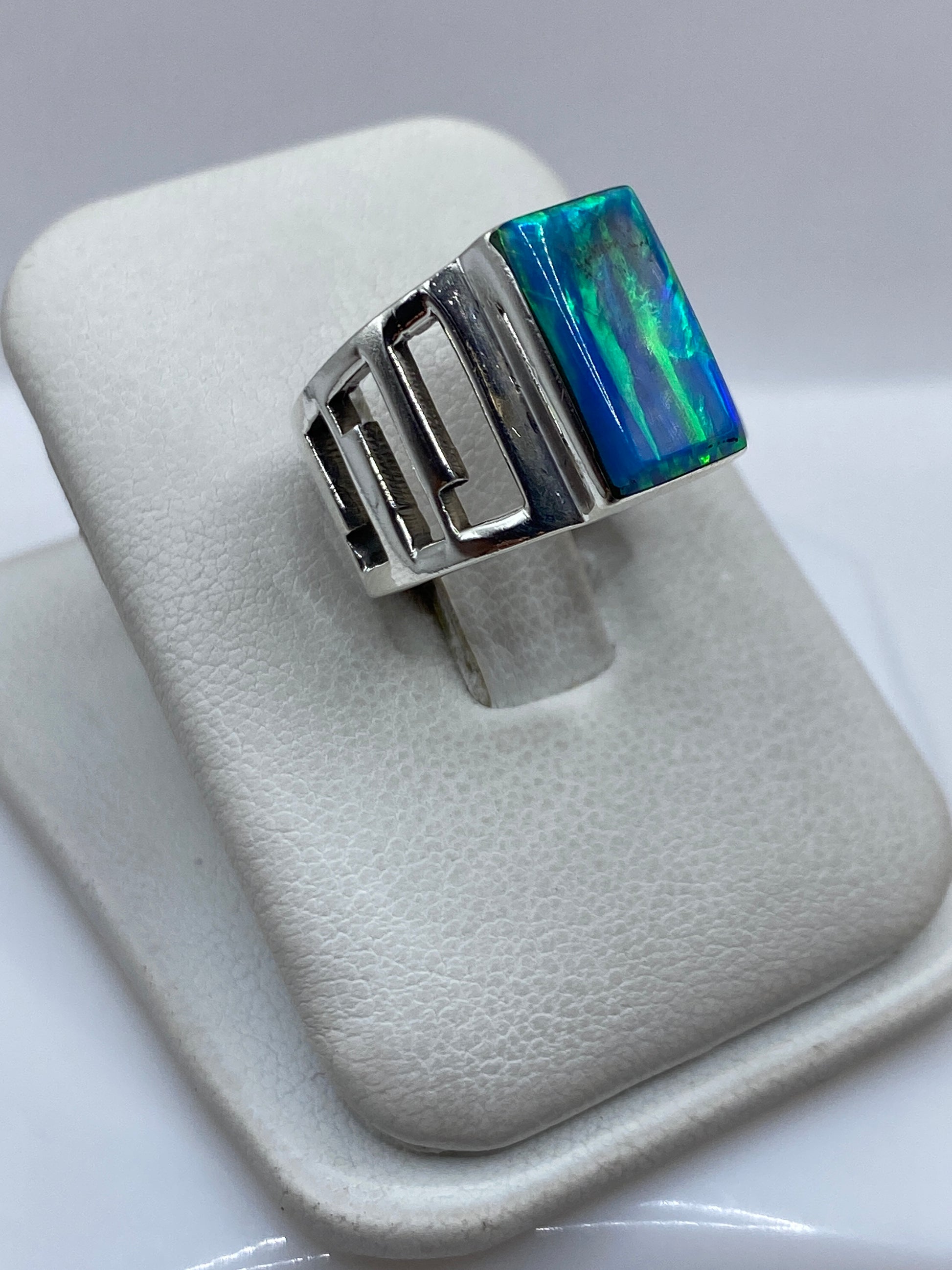 Vista frontal del anillo mostrando la piedra azul cielo con reflejos verdes