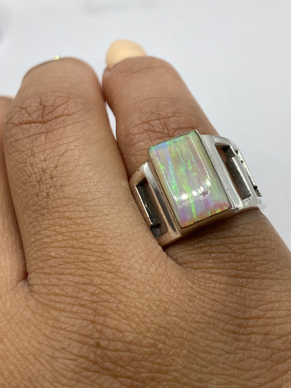 Anillo en dedo mostrando iridiscencia natural del ópalo de fuego de Taxco