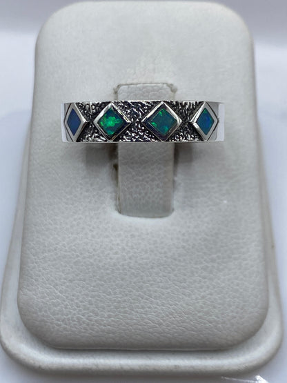 Anillo de plata .950 con ópalo de fuego azul cielo, vista frontal sobre presentador blanco
