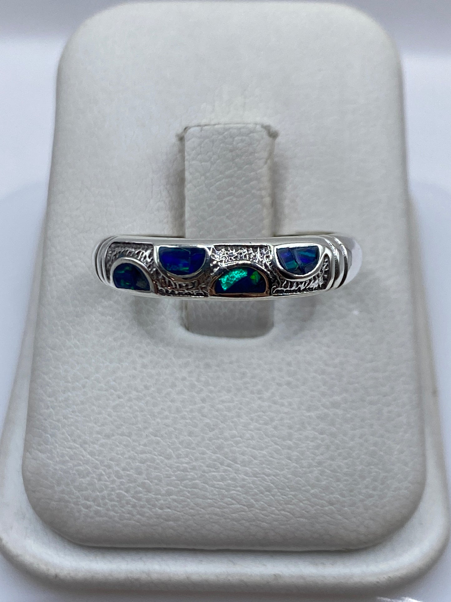 Anillo de plata .950 con ópalo de fuego azul en la mano de una persona unisex