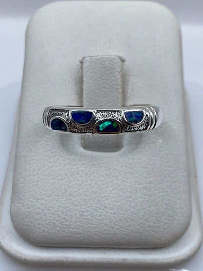 Anillo de plata .950 con ópalo de fuego azul en la mano de una persona unisex