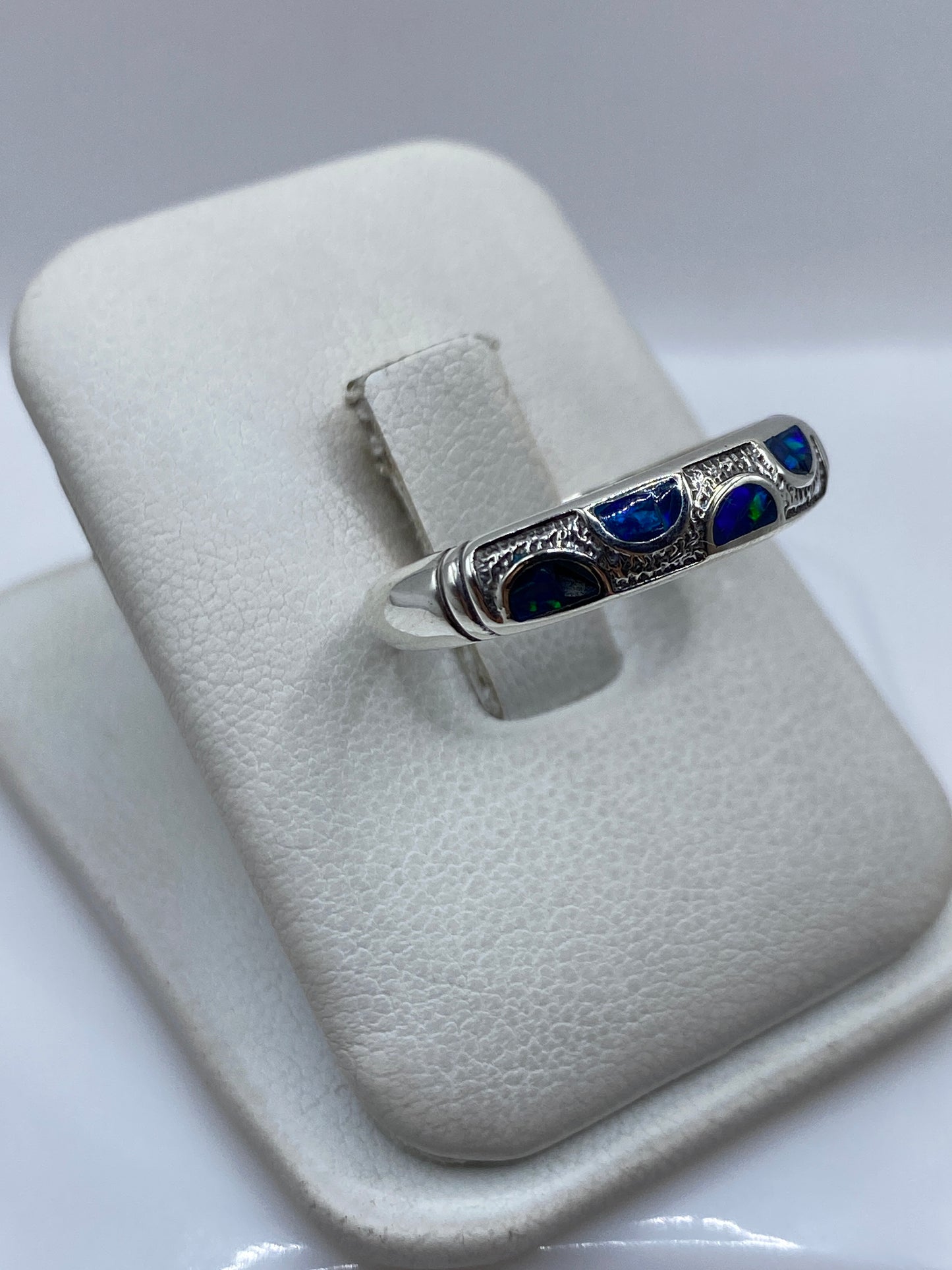 Detalle del ópalo de fuego azul con destellos verdes en el engaste de plata