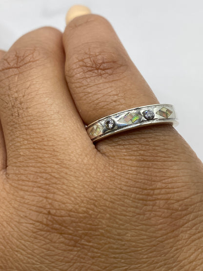 Anillo puesto en dedo mostrando el Quinto .950 y brillo iridiscente del ópalo