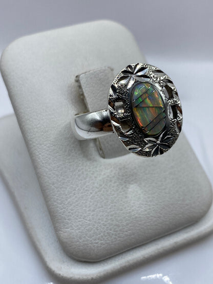Vista lateral del anillo de plata .950 con ópalo, sobre dedo, destacando el engaste artesanal