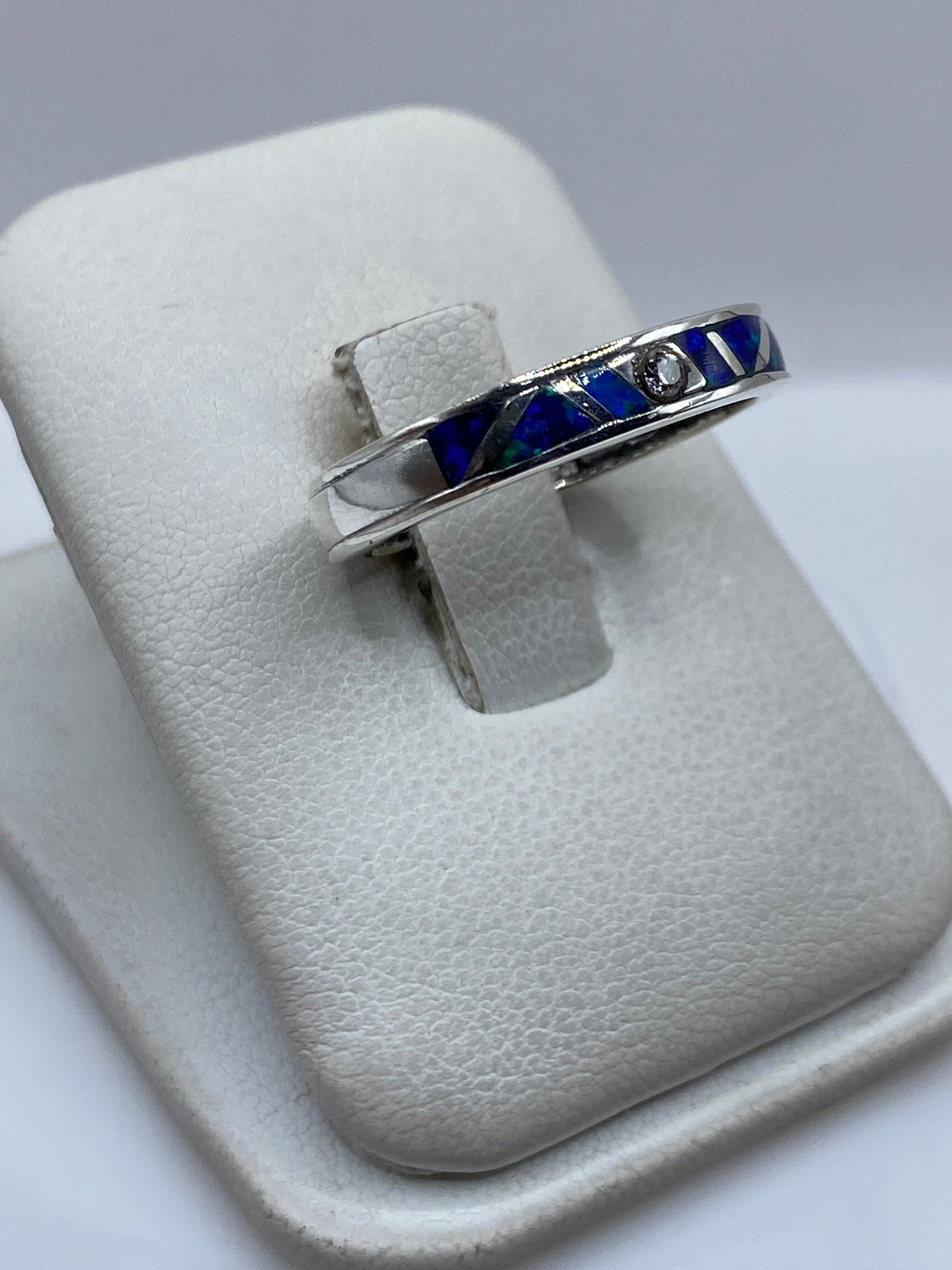 Detalle lateral del anillo mostrando el engaste artesanal y el color azul del ópalo