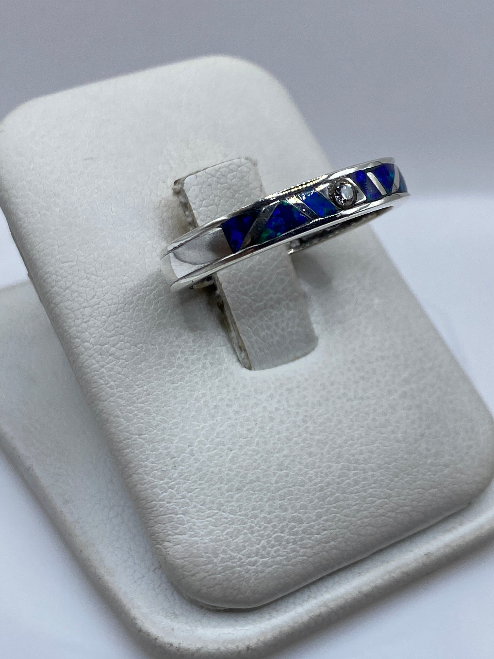 Detalle lateral del anillo mostrando el engaste artesanal y el color azul del ópalo