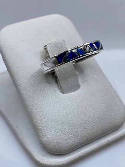 Detalle lateral del anillo mostrando el engaste artesanal y el color azul del ópalo