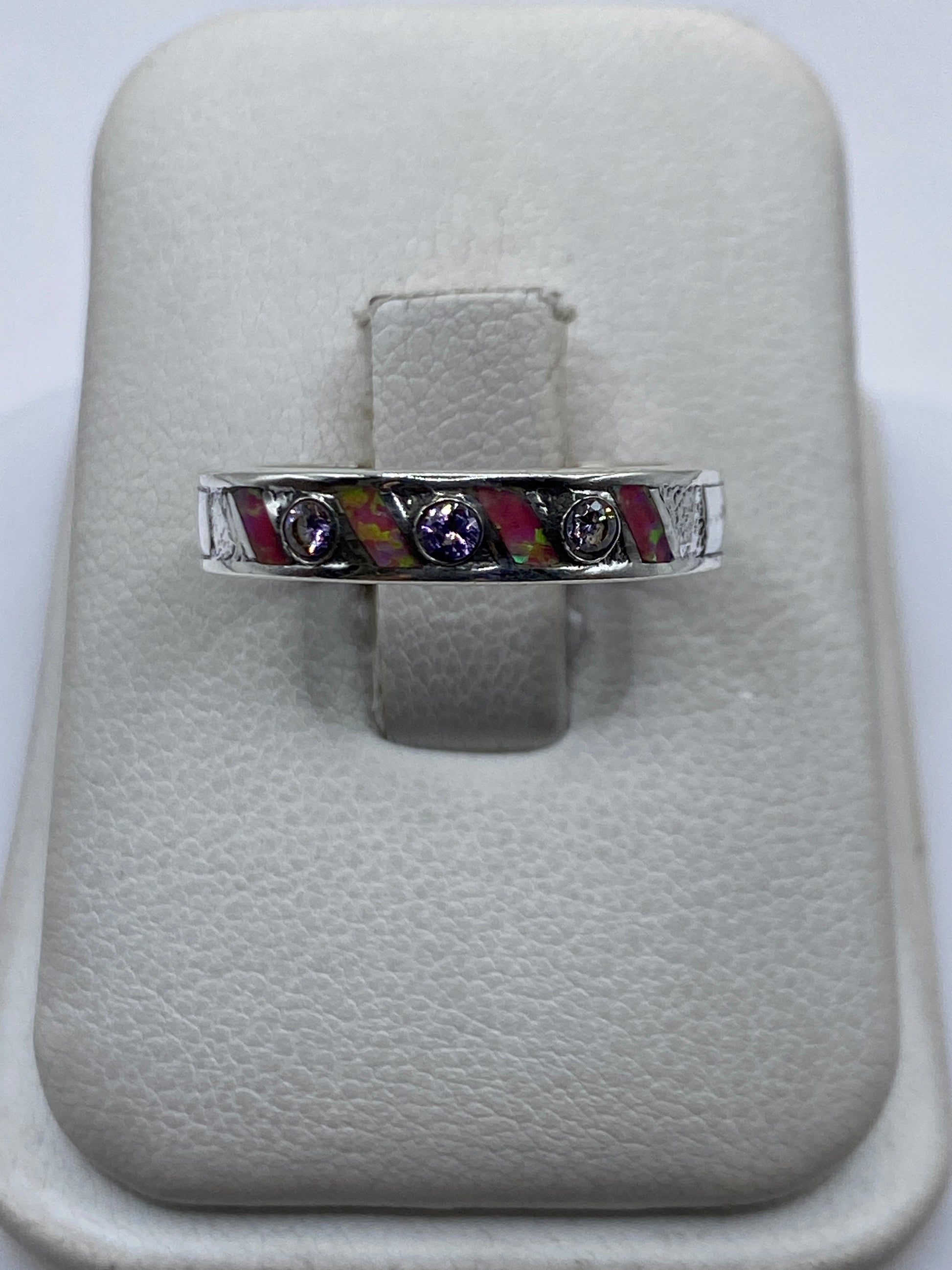 Anillo de plata .950 con ópalo de fuego rosa en la mano, mostrando el fuego cálido de la piedra
