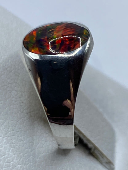 Detalle del ópalo de fuego con reflejos rojos, verdes y azules en la mano