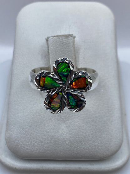 Anillo de plata floral con ópalo de fuego multicolor visto desde arriba, mostrando verde, naranja y azul