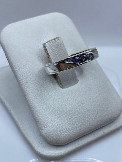 Detalle lateral del anillo mostrando el ópalo de fuego capturando luz naranja y verde