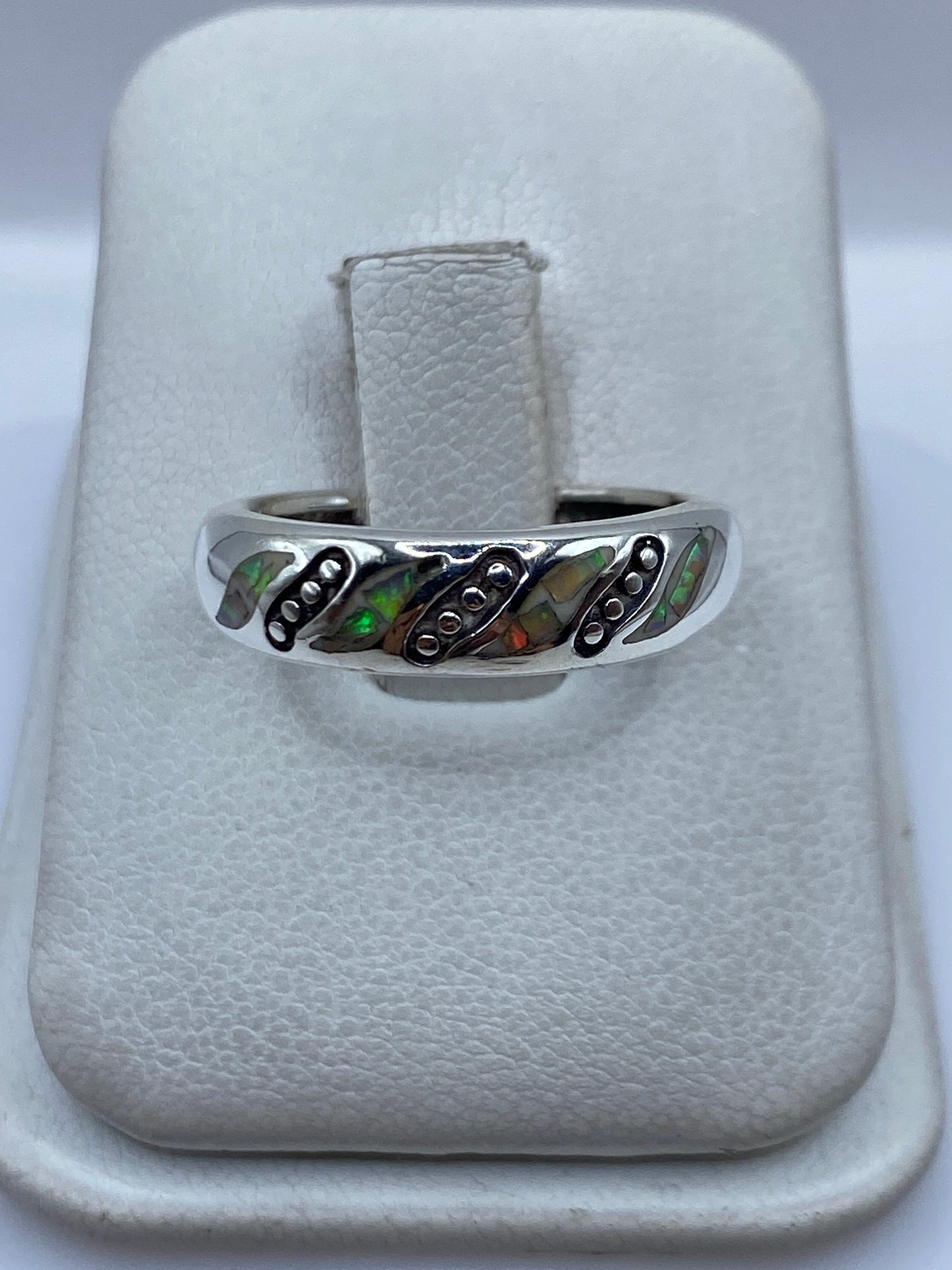 Anillo de plata con ópalo de fuego multicolor visto de frente mostrando el juego de colores