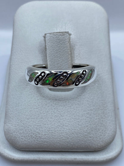 Anillo de plata con ópalo de fuego multicolor visto de frente mostrando el juego de colores