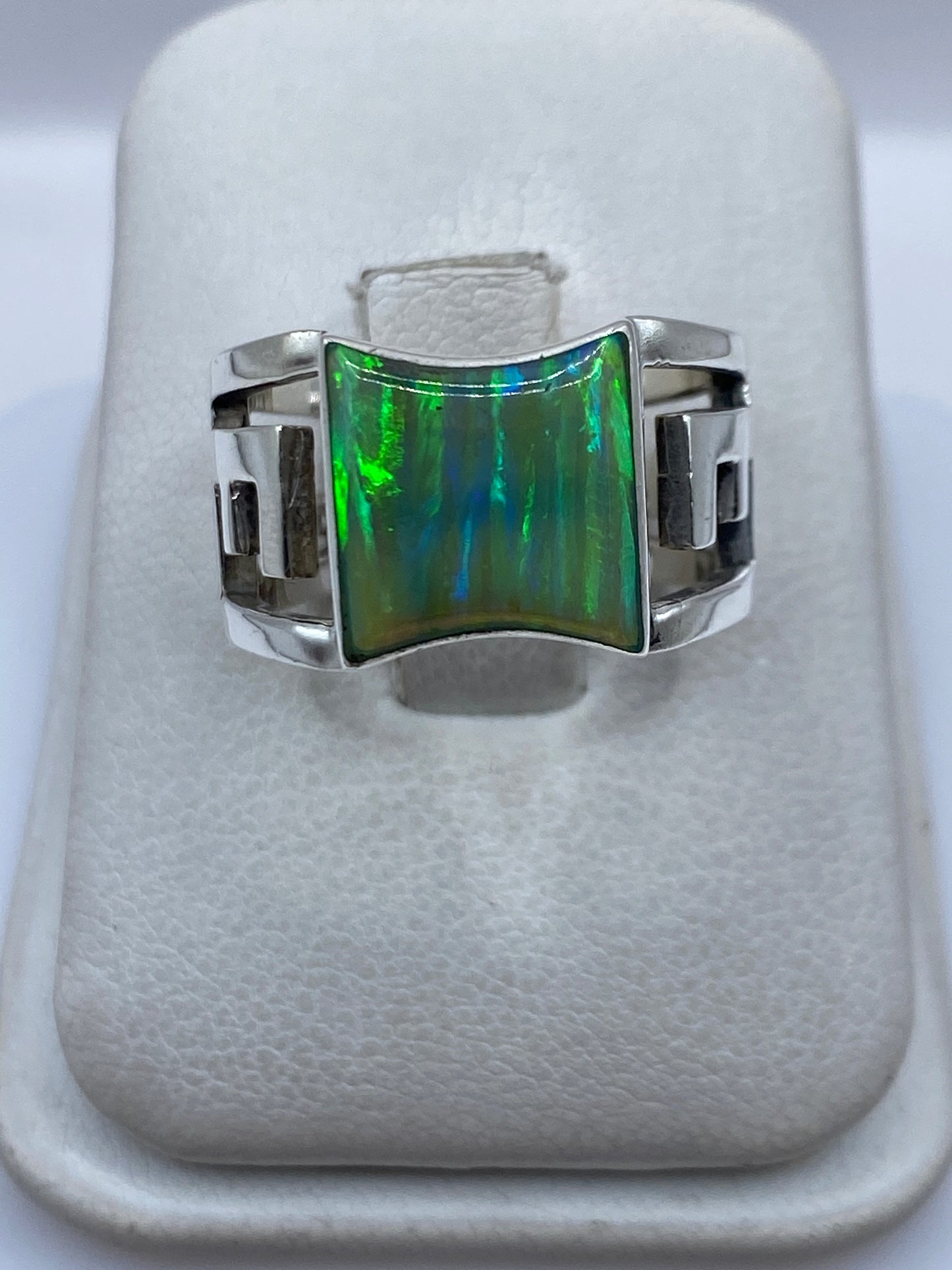 Anillo de plata .950 con ópalo de fuego verde limón en la mano de una mujer, mostrando el brillo arcoíris