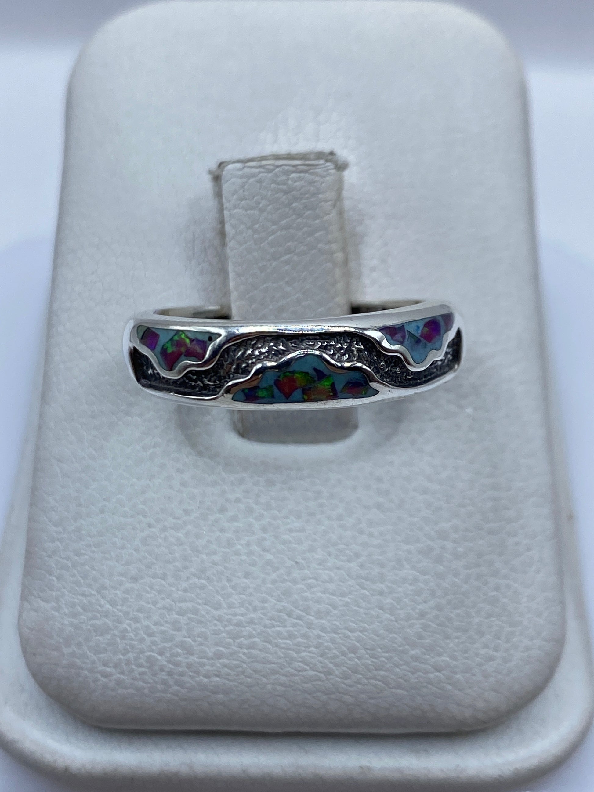 Anillo de plata .950 con Ópalo de Fuego morado, incrustación a mano, visto de frente en estuche blanco