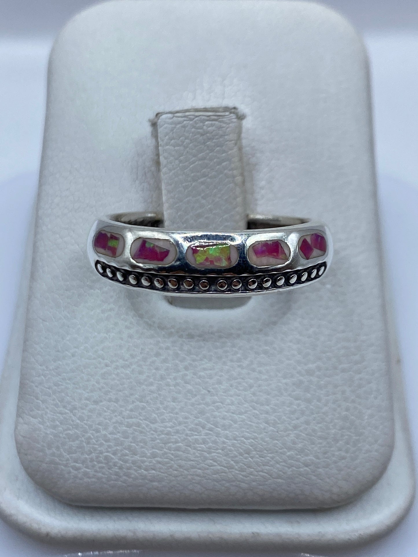 Anillo de plata .950 con ópalo de fuego rosa engastado en los dedos de una mano