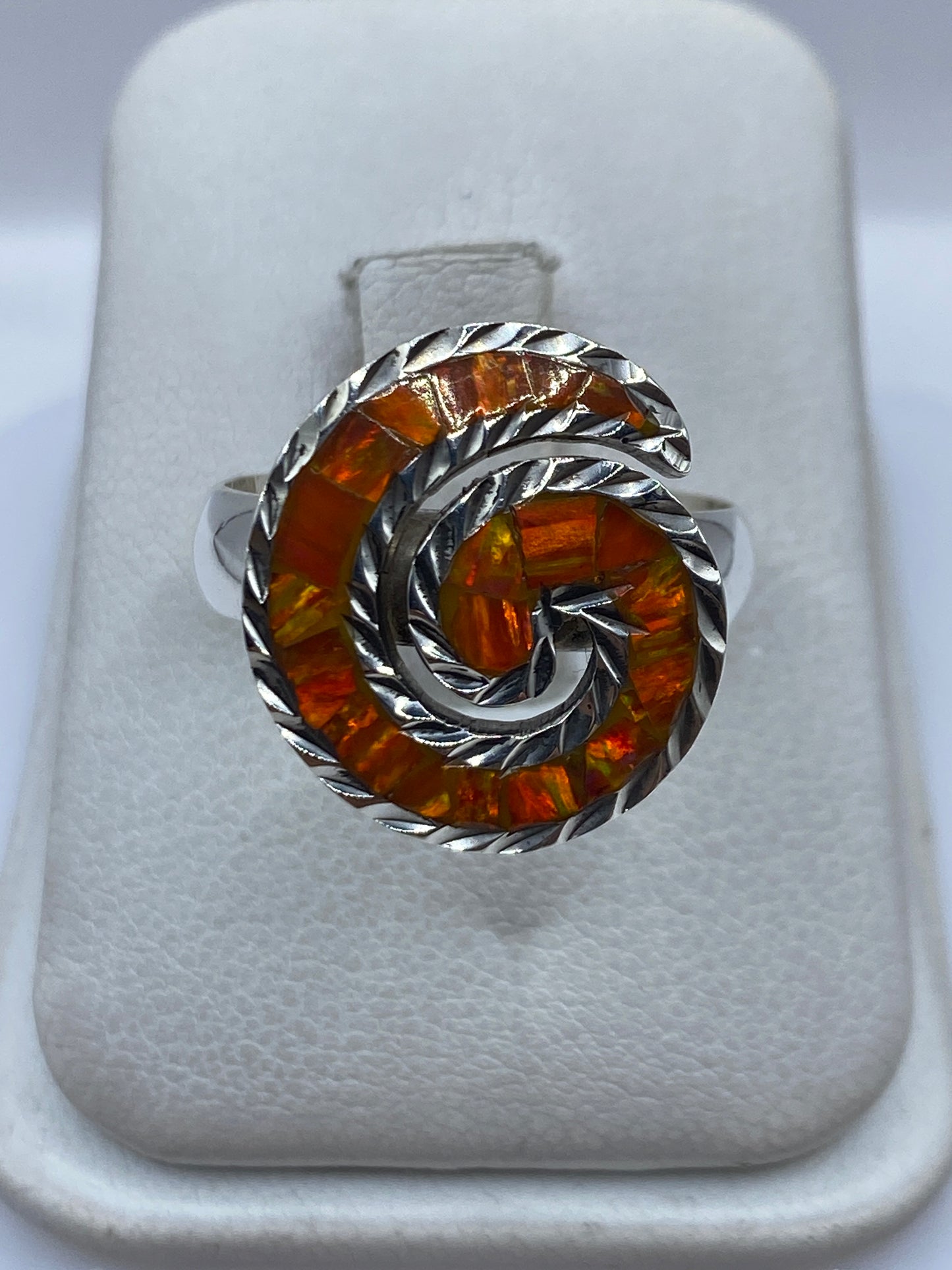 Anillo de plata .925 con ópalo de fuego naranja en forma de espiral sobre fondo blanco