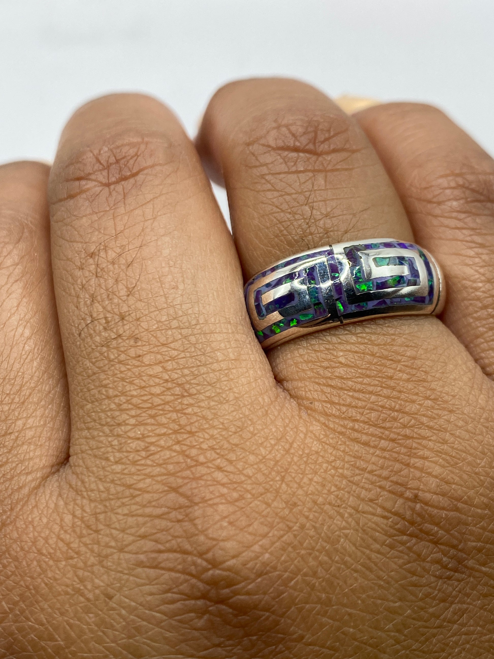 Anillo en mano mostrando el juego de luz del ópalo