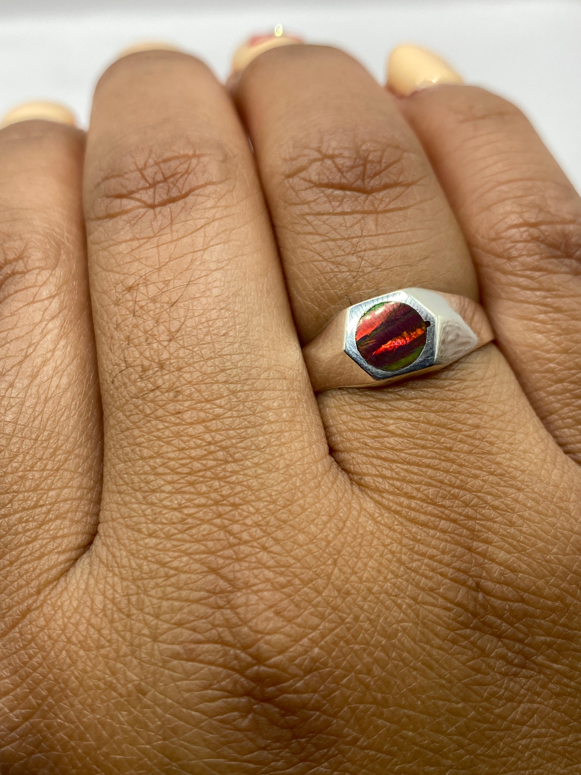Anillo de ópalo de fuego en mano mostrando la versatilidad unisex