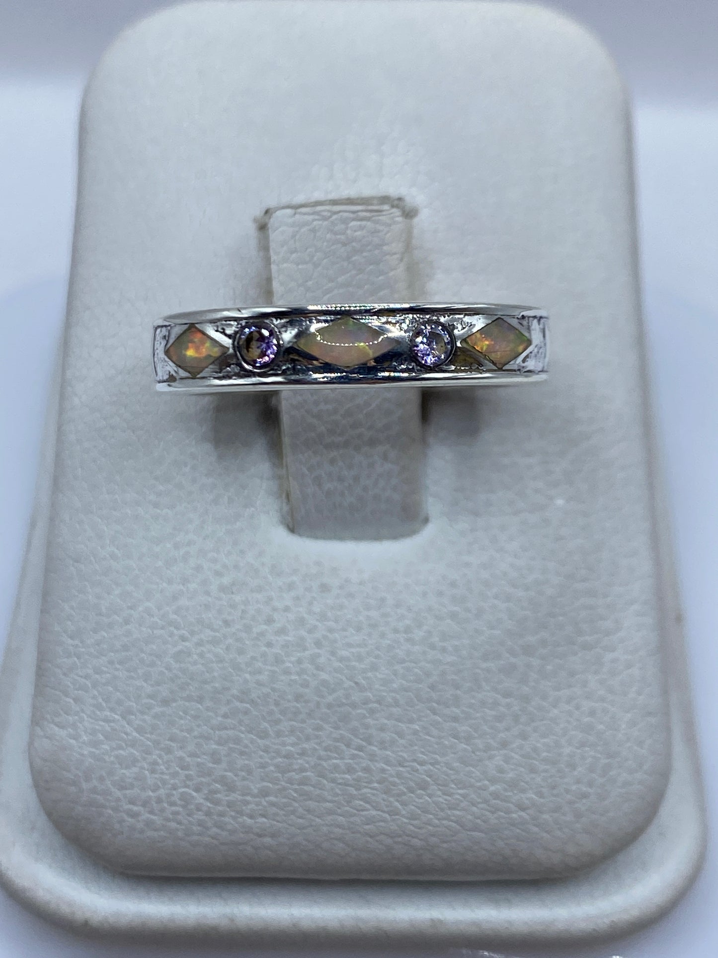 Anillo de plata .950 con ópalo de fuego multicolor en tonos naranja, rojo y verde, sobre almohada blanca